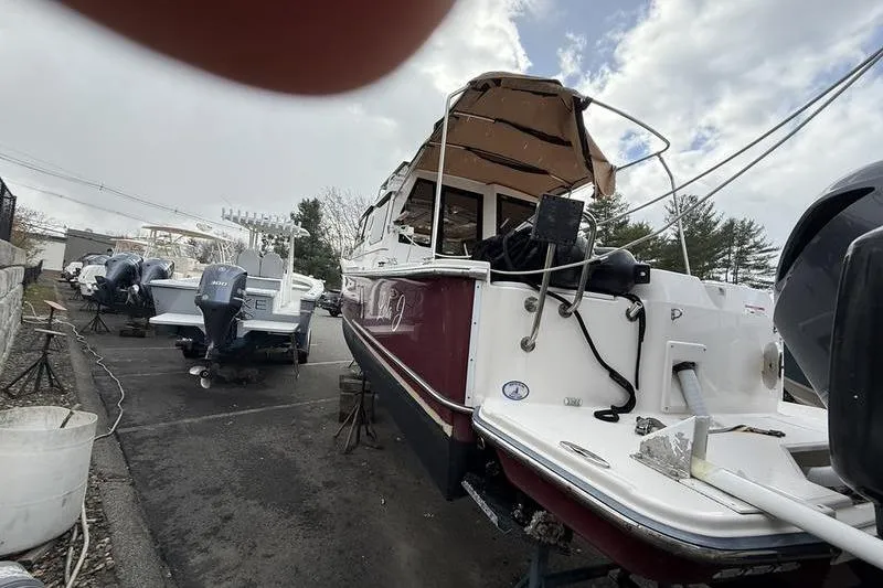 Slide: The Image of 2021 Ranger Tugs R-27 boat in storage yard, surrounded by other vessels. - 9