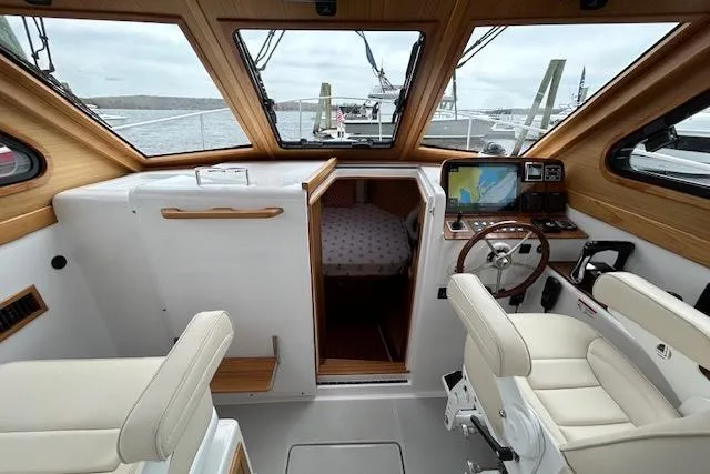 Slide: The Image of 2024 True North 34 Outboard Express boat interior with helm, seating, and cabin view. - 11