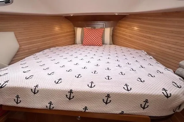 Slide: The Image of Cozy cabin interior of 2024 True North 34 Outboard Express with anchor-themed bedding. - 13