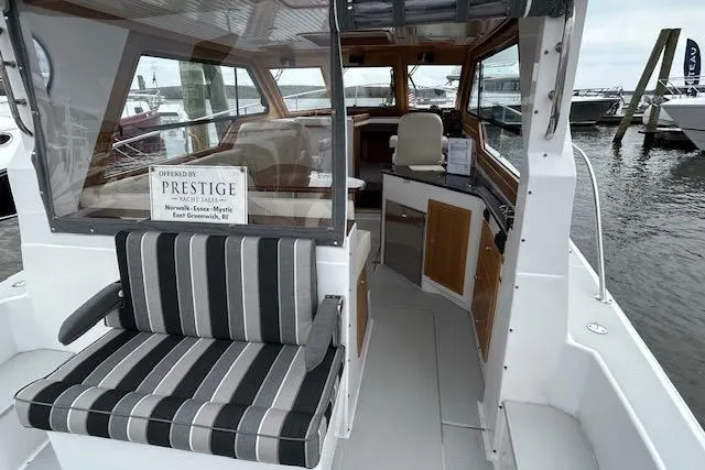Slide: The Image of 2024 True North 34 Outboard Express boat interior with striped seating and helm view. - 15