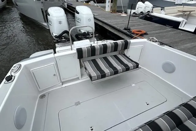 Slide: The Image of 2024 True North 34 Outboard Express boat with striped seating and dual engines at dock. - 16