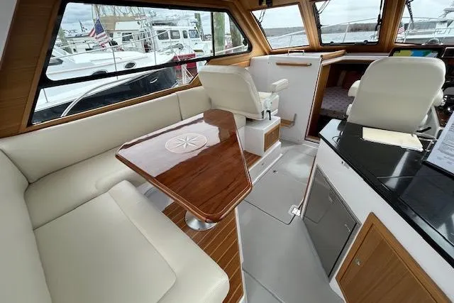 Slide: The Image of Interior of 2024 True North 34 Outboard Express, featuring elegant seating and wooden table. - 17