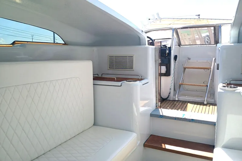Slide: The Image of Interior of 2006 Royal Denship Royal Limo yacht with white seating and wooden accents. - 16