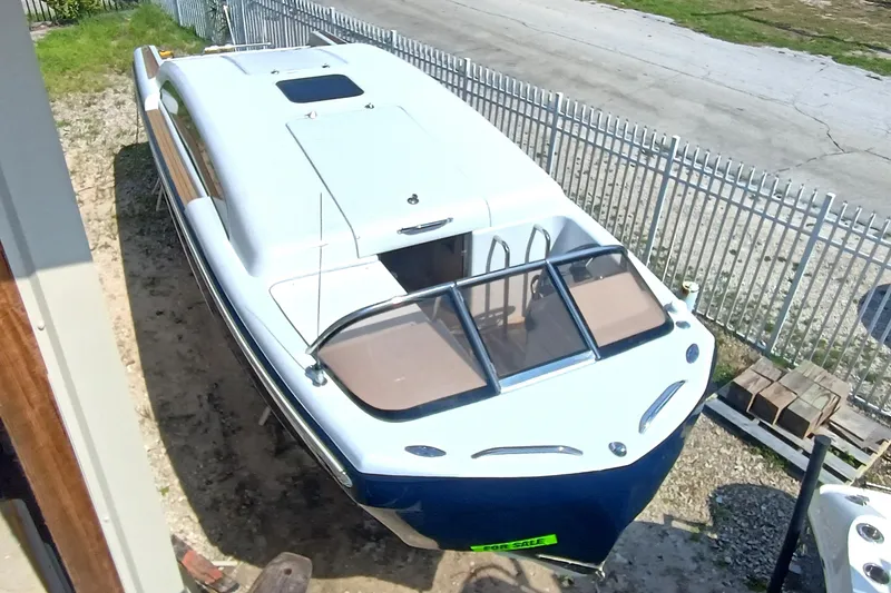 Slide: The Image of 2006 Royal Denship Royal Limo boat for sale, parked near a fence. - 2