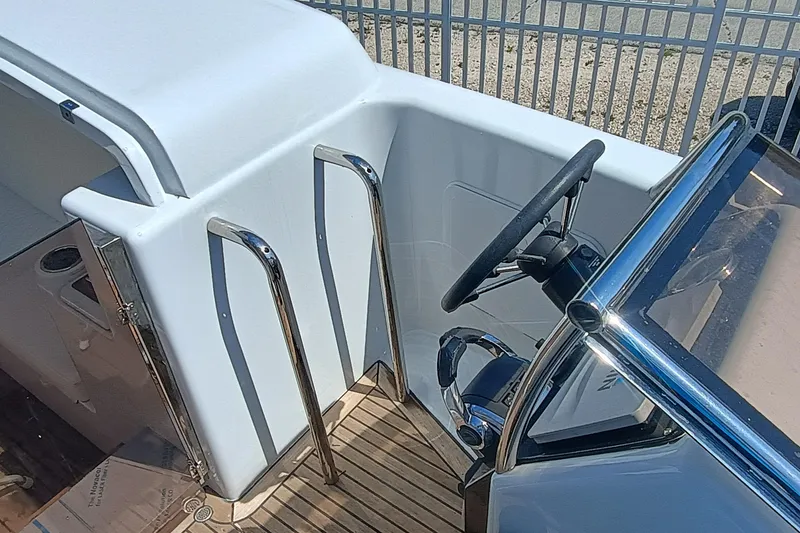 Slide: The Image of 2006 Royal Denship Royal Limo boat steering area with chrome details and wooden deck. - 24