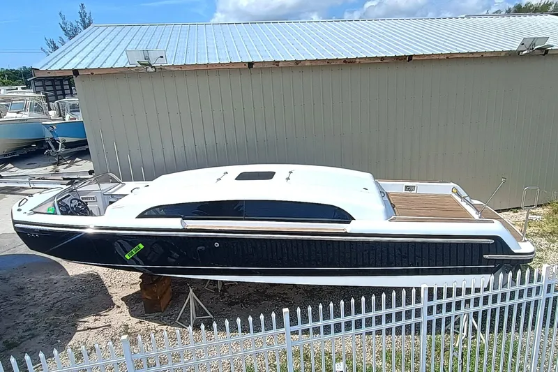 Slide: The Image of 2006 Royal Denship Royal Limo boat on display near a metal fence. - 4