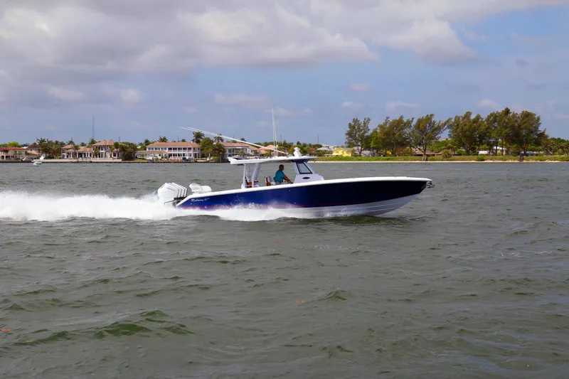 Slide: The Image of 2026 Bahama 41 GT boat cruising on a scenic waterway with coastal homes in the background. - 14