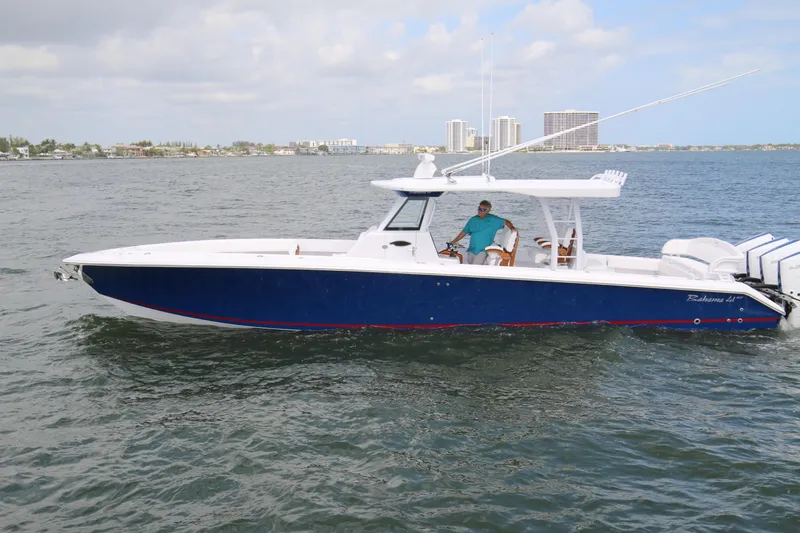 Slide: The Image of 2026 Bahama 41 GT boat cruising on water with city skyline in background. - 28