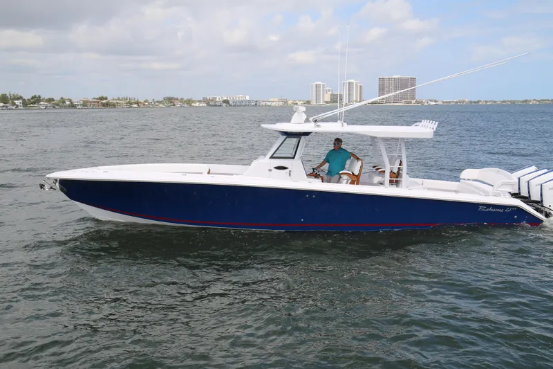 Slide: The Image of 2026 Bahama 41 GT boat cruising on open water with city skyline in background. - 29