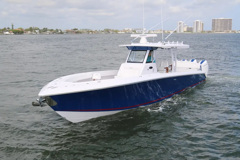 Slide: The Image of 2026 Bahama 41 GT boat cruising on open water, featuring sleek blue and white design. - 32