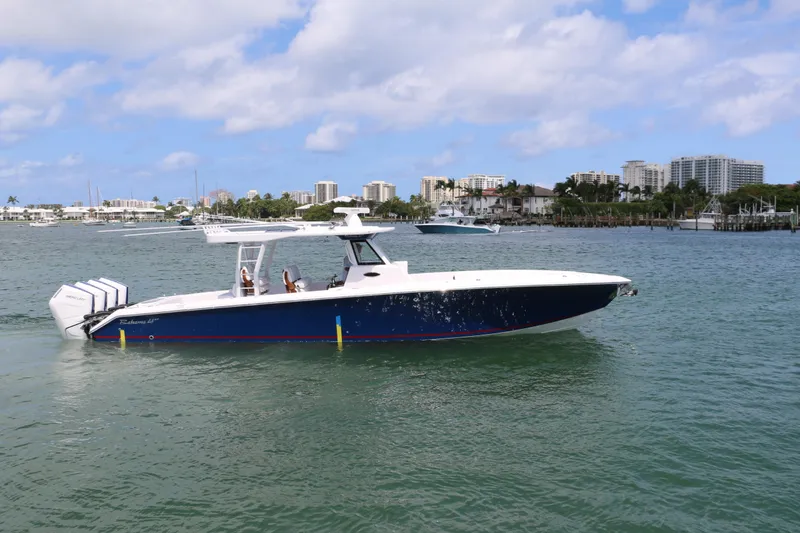 Slide: The Image of 2026 Bahama 41 GT boat cruising on a sunny day near a coastal cityscape. - 4