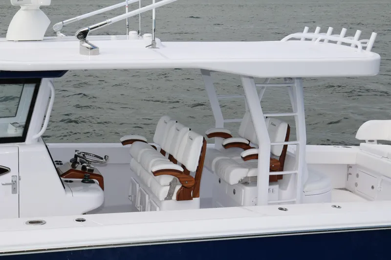 Slide: The Image of 2026 Bahama 41 GT boat interior with white seating and helm, on calm water. - 61