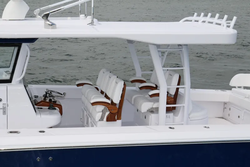 Slide: The Image of 2026 Bahama 41 GT boat with sleek seating and helm, on calm water. - 62