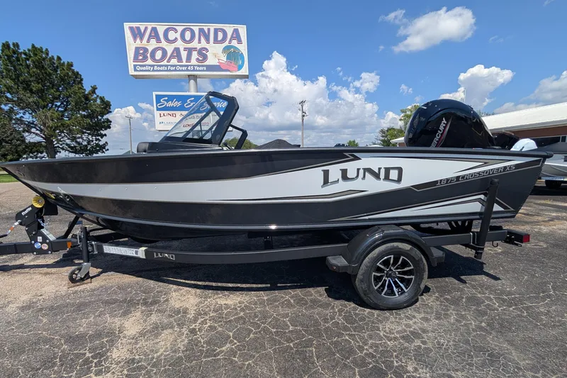 Slide: The Image of 2026 Lund 1875 Crossover XS boat on trailer at Waconda Boats dealership. - 2