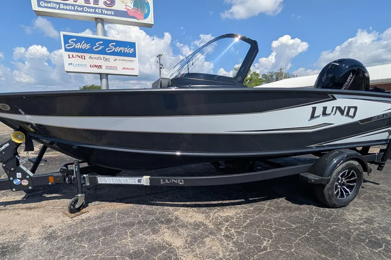 Slide: The Image of 2026 Lund 1875 Crossover XS boat on trailer, displayed at sales and service center. - 5