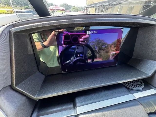 Slide: The Image of Simrad display on 2025 Barletta Lusso L25MAT boat dashboard, reflecting steering wheel and surroundings. - 17