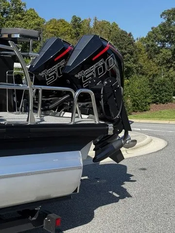 Slide: The Image of 2025 Barletta Lusso L25MAT boat with twin outboard motors, parked on a sunny day. - 4