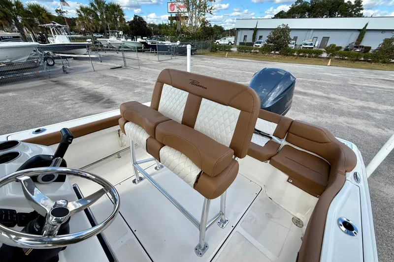 Slide: The Image of 2024 Pioneer 222 Islander boat interior with brown and white seating, steering wheel, and engine view. - 4