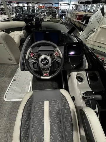 Slide: The Image of 2025 Barletta Boats R23UCA interior with modern steering and dashboard in showroom. - 10