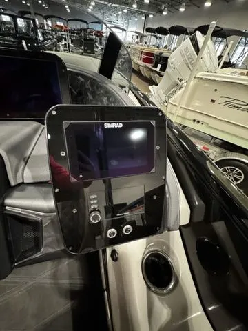 Slide: The Image of 2025 Barletta Boats R23UCA dashboard with Simrad display in a showroom. - 11