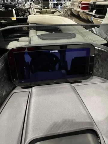 Slide: The Image of 2025 Barletta Boats R23UCA dashboard with Simrad display in a showroom setting. - 12