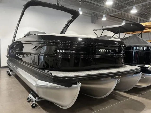 Slide: The Image of 2025 Barletta Boats R23UCA pontoon in showroom, sleek black design, modern features. - 3