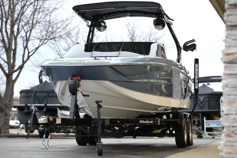 Slide: The Image of 2026 Supreme S220 boat on trailer, parked outdoors, showcasing sleek design and modern features. - 23