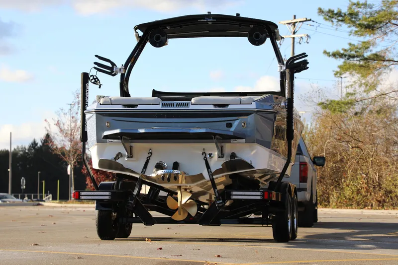 Slide: The Image of 2026 Supreme S220 boat on trailer, rear view, parked outdoors. - 24