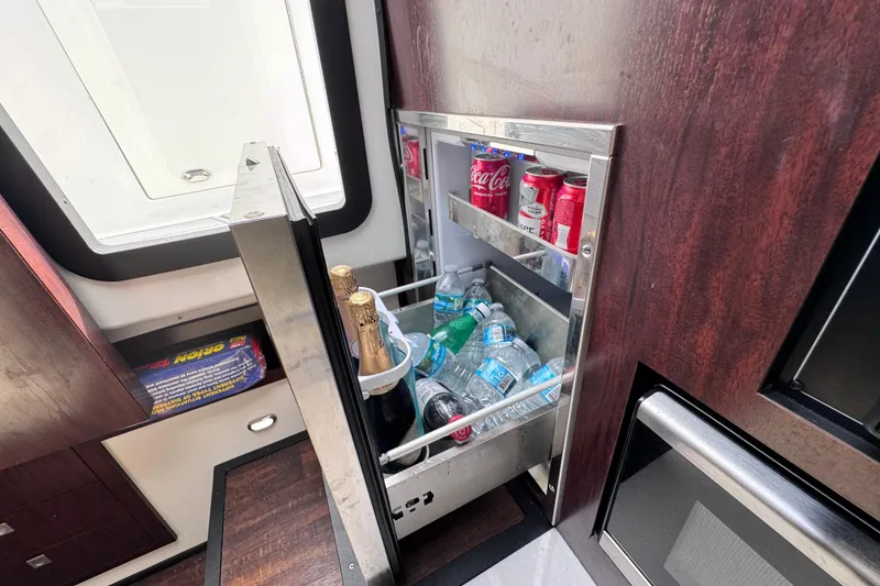 Slide: The Image of Mini fridge stocked with drinks on a 2021 Monterey 378 Super Express boat. - 14