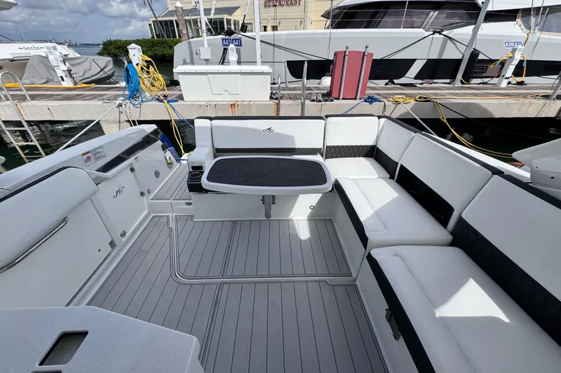 Slide: The Image of 2021 Monterey 378 Super Express boat interior with sleek seating and table at dock. - 21