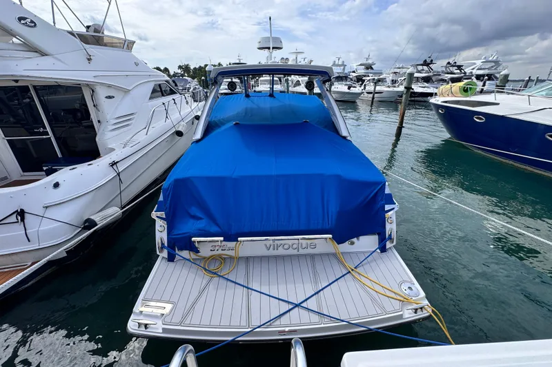 Slide: The Image of 2021 Monterey 378 Super Express yacht docked, covered with blue tarp, surrounded by other boats. - 6