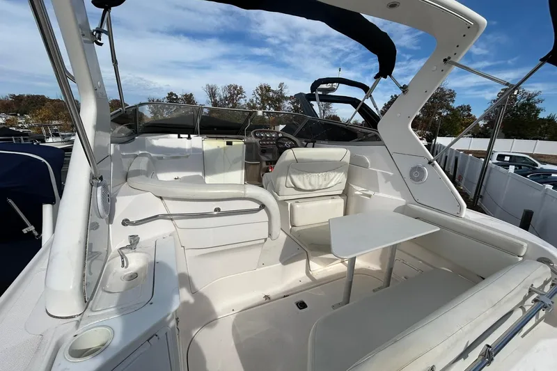 Slide: The Image of 2004 Regal Commodore 2860 boat interior with seating and table under blue sky. - 8