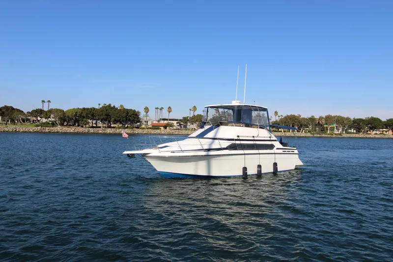 The Image of 1990 Carver 3467 Santego yacht on calm water with clear blue sky. - 0