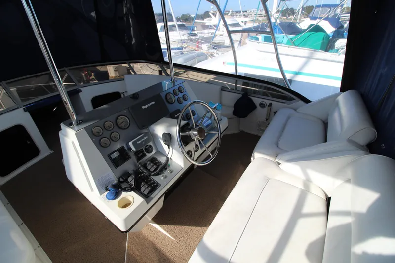 Slide: The Image of 1990 Carver 3467 Santego yacht cockpit with steering wheel and white seating. - 11
