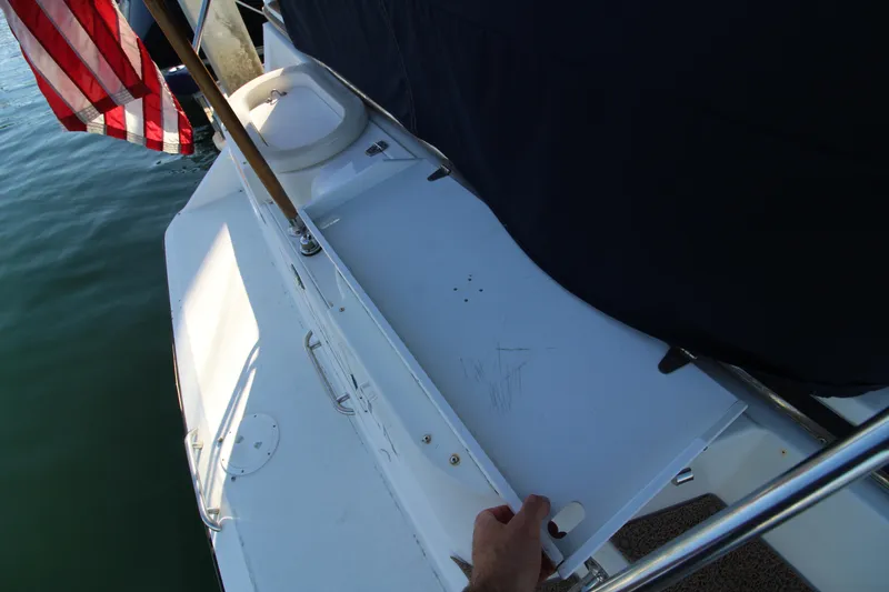 Slide: The Image of 1990 Carver 3467 Santego boat deck with American flag, docked on calm water. - 22