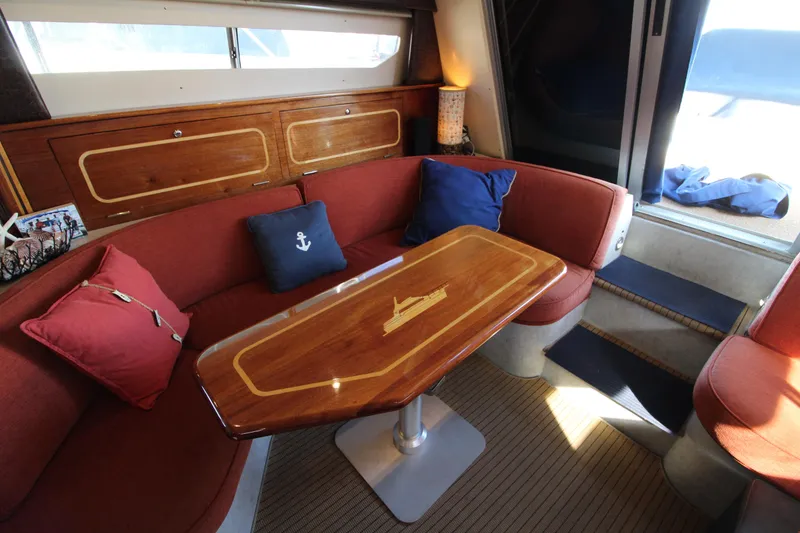 Slide: The Image of Interior of 1990 Carver 3467 Santego yacht with red seating and wooden table. - 26