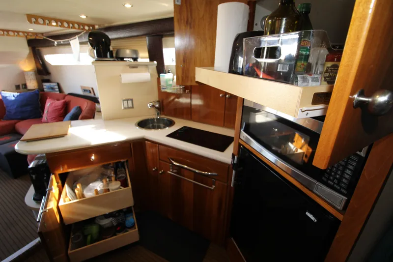 Slide: The Image of 1990 Carver 3467 Santego yacht interior kitchen with wooden cabinets and modern appliances. - 28