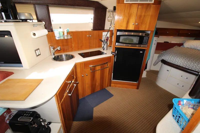 Slide: The Image of 1990 Carver 3467 Santego yacht interior with kitchen, microwave, and bed. - 29