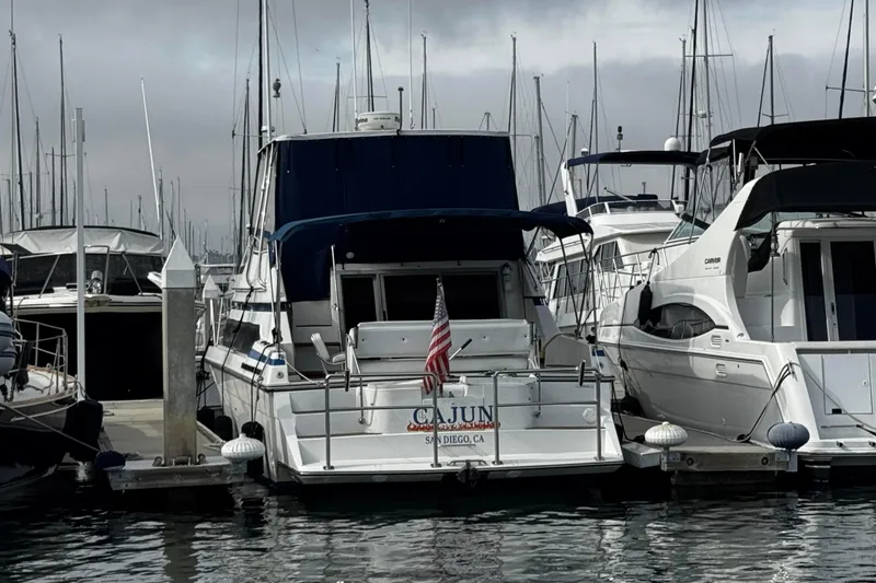 Slide: The Image of 1990 Carver 3467 Santego yacht docked in marina, San Diego, with American flag. - 3