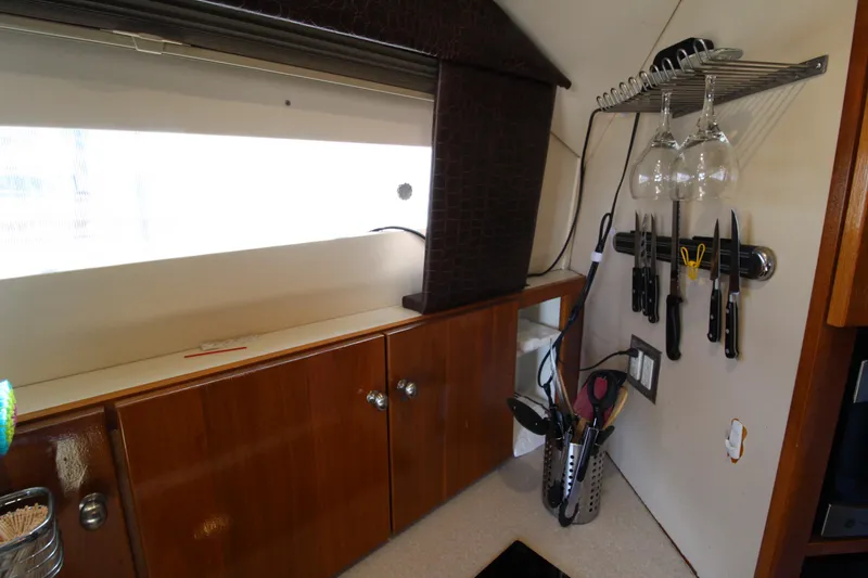 Slide: The Image of 1990 Carver 3467 Santego interior with wooden cabinets and kitchen utensils. - 30