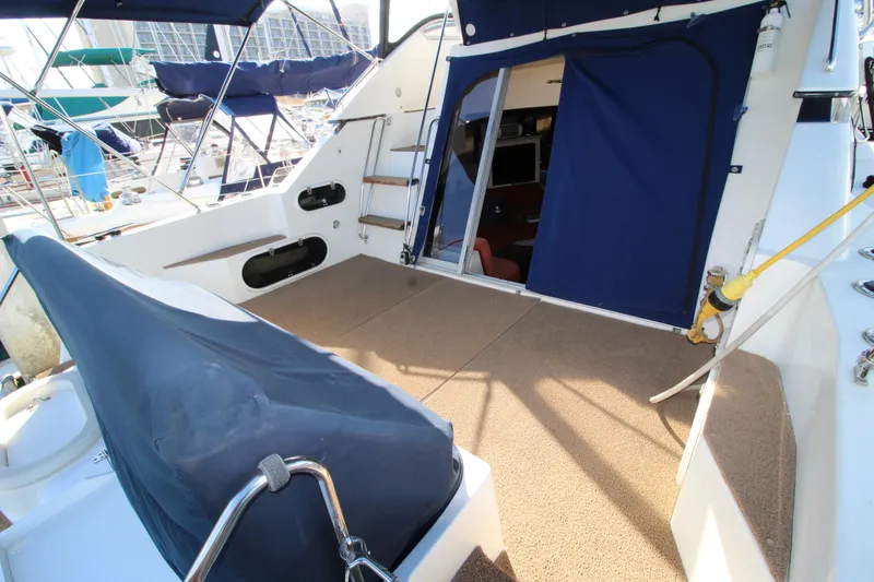 Slide: The Image of 1990 Carver 3467 Santego yacht deck with blue canvas cover and open cabin door. - 4