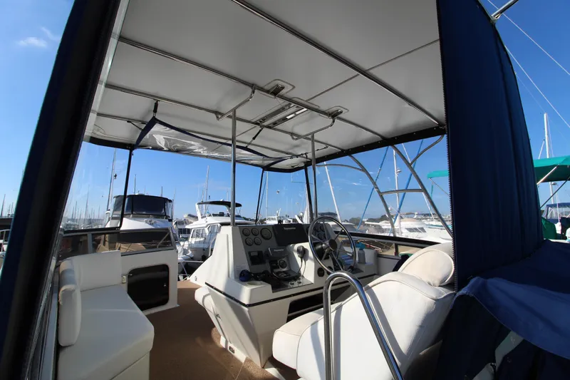 Slide: The Image of 1990 Carver 3467 Santego yacht cockpit with helm, marina view, and clear blue sky. - 9