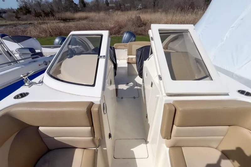 Slide: The Image of 2021 Scout 240 Dorado boat interior with beige seating and dual consoles. - 10