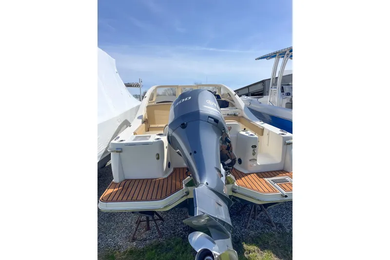 Slide: The Image of 2021 Scout 240 Dorado boat with powerful outboard motor, docked on a sunny day. - 12