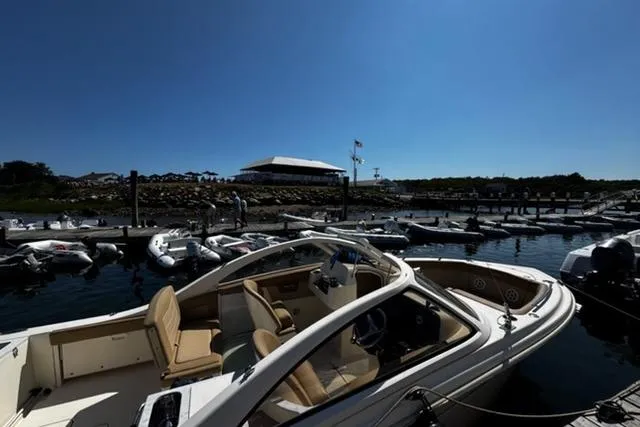 Slide: The Image of 2021 Scout 240 Dorado boat docked at marina under clear blue sky. - 2