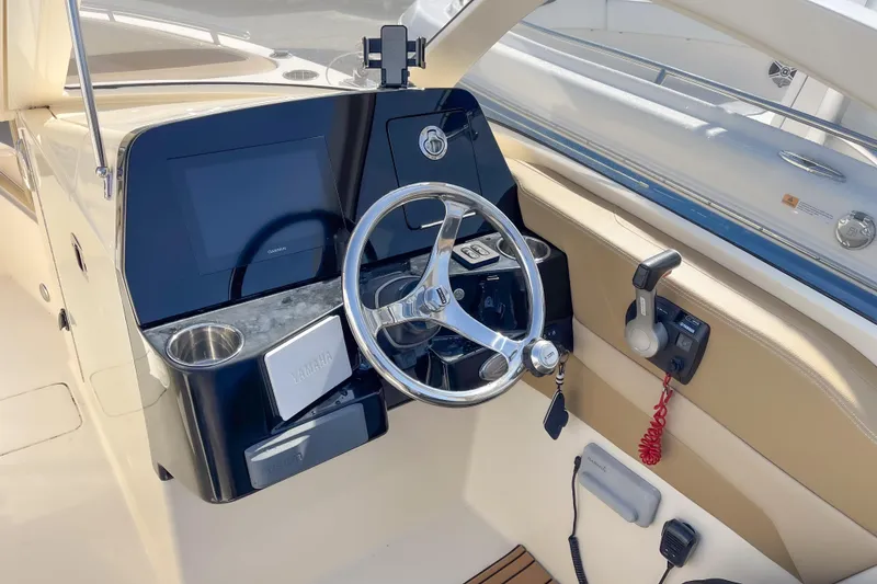 Slide: The Image of 2021 Scout 240 Dorado boat dashboard with steering wheel and controls. - 5