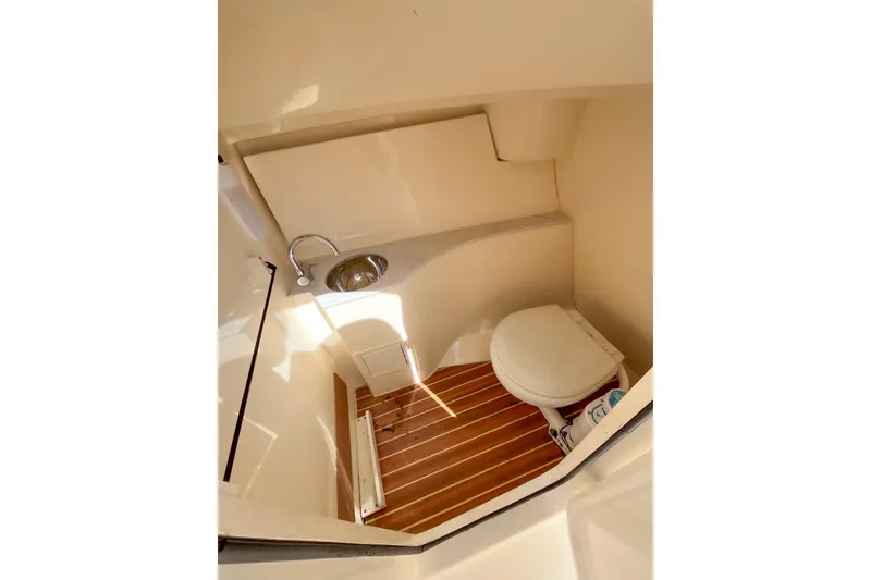 Slide: The Image of 2021 Scout 240 Dorado boat interior with compact bathroom and wooden flooring. - 6