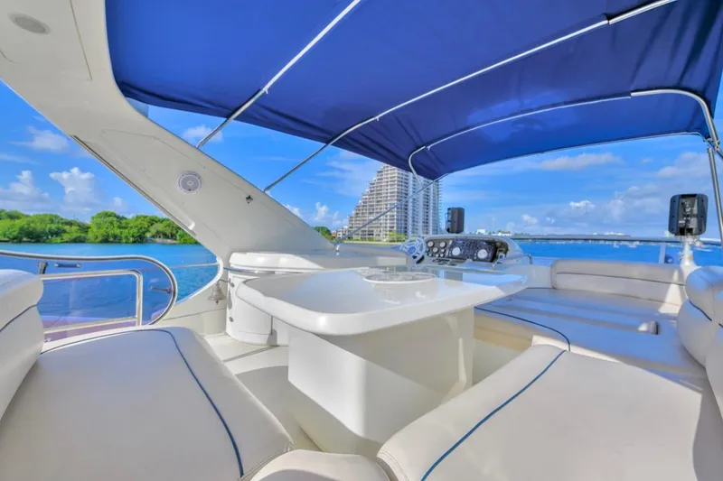 Slide: The Image of Luxurious 2010 Azimut 62 Evolution yacht interior with blue canopy and scenic waterfront view. - 13
