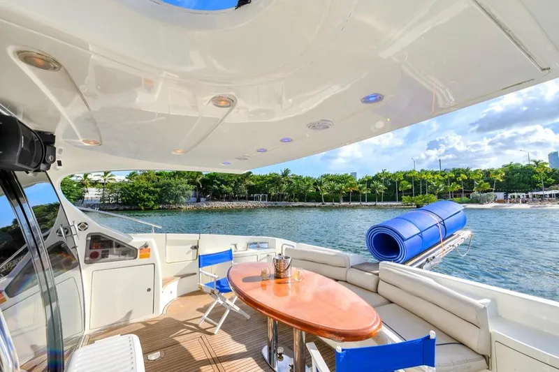 Slide: The Image of Luxurious 2010 Azimut 62 Evolution yacht deck with seating, table, and scenic waterfront view. - 2