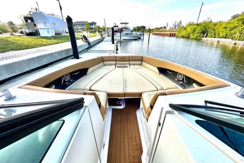Slide: The Image of 2015 Sea Ray 350 SLX boat with spacious seating, docked by a serene waterway. - 14